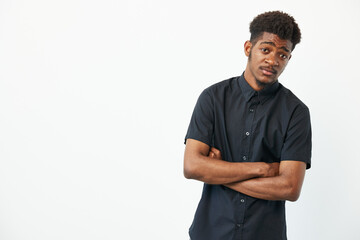 Black man with crossed arms, wearing a stylish black shirt, exuding a confident yet approachable...