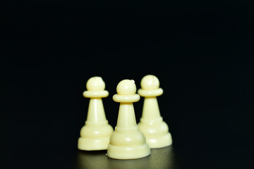 Chess pieces pawns, white on a black background.