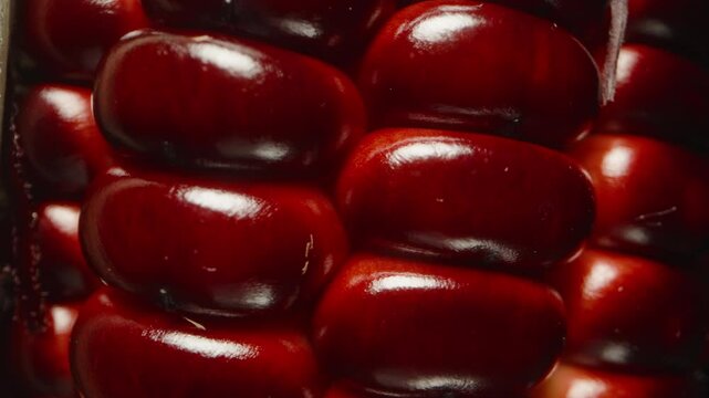 Close-Up of Red Corn Kernels and Pale Husk Rotating in Macro View Against a Dark Background, Showing Organic Detail and Moist Surface, Studio Isolated, Fresh Harvest Concept