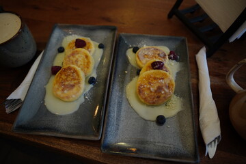 Cup of coffee with cottage cheese pancakes,served in a cozy café