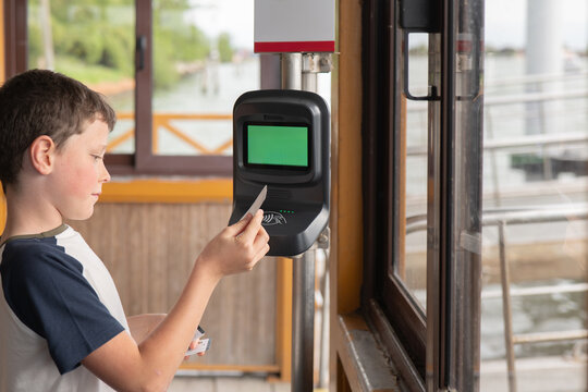 Young boy using Venice vaporetto ticket validator