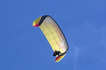 Tandem Paraglider flying in a blue sky	