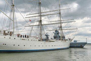 Bark Gorch Fock I and bow of German corvette in Stralsund harbor under heavy clouds