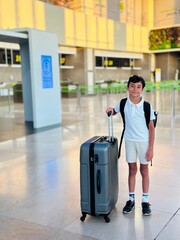 A boy with a suitcase at the airport 