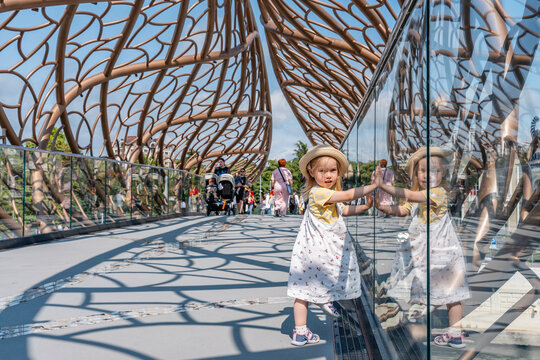 Sochi, Russia - 8 June 2025: Child girl walks across an unusual pedestrian bridge in Sochi