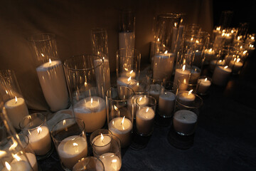 Numerous candles in glass holders emit warm, soft light, creating a serene and peaceful atmosphere....