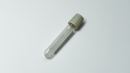 Naklejka premium A single empty blood collection tube with a gray cap placed diagonally on a white background. Commonly used for glucose testing in medical laboratories.