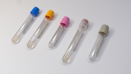 Five blood collection tubes with different color-coded caps (blue, yellow, pink, purple, gray) arranged diagonally on a white background. Used for various types of laboratory tests.