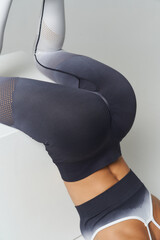 Athletic person doing a handstand in sleek, dark gradient leggings featuring mesh texture on a smooth surface showcases stylish and dynamic activewear suitable for fitness and yoga