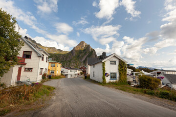 Charming village streets with mountains in background under a partly cloudy sky in Norway