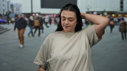 Woman standing on a busy city street with a crowd in the background, showcasing urban outdoor...