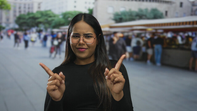Woman shows finger gesture on street in a young latin hispanic outdoor market city.