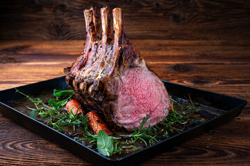 Dry aged bone-in back rack of veal loin roasted with herbs and spices served on a black board