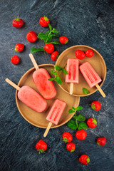Frozen dessert - homemade strawberry ice lolly popsicle  with yogurt and fresh strawberrie offered...