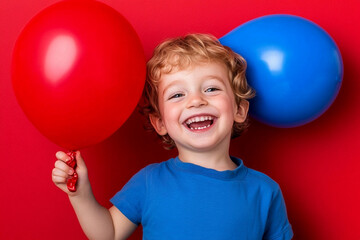 Child joyfully holds large red and blue balloons