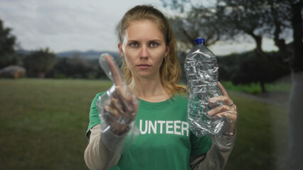 Blonde woman bottle holding outdoors plastic volunteer recycling awareness ecology conservation...