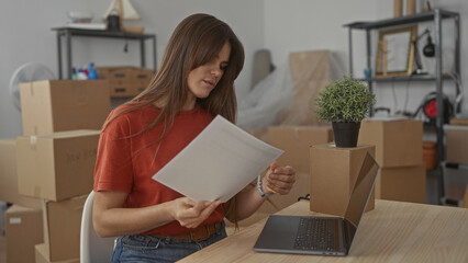 Woman examining documents in living room surrounded by packing boxes and laptop signifies moving, woman, new, home, unpacking, interior, apartment, paperwork, work, technology