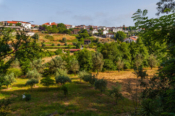 A serene rural scene featuring a village with red-tiled roofs