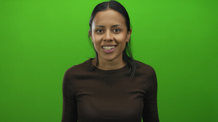 Young woman smiling against an isolated green background wall, expressing joy and positivity, suitable for diverse creative and professional projects.
