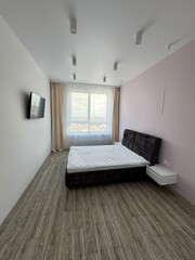 Modern Bedroom Interior with Large Window and Wall-Mounted TV