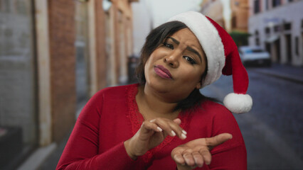 Woman gesturing for money outdoors wearing a santa hat, capturing a festive street city scene with...