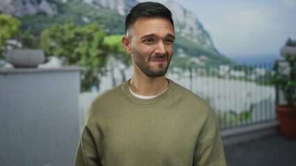 Young hispanic man outdoors on urban street pinching nose due to bad smell, showcasing an...