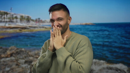 Hispanic man at seashore making a gesture of fear or disgust wearing a sweater, ocean in...