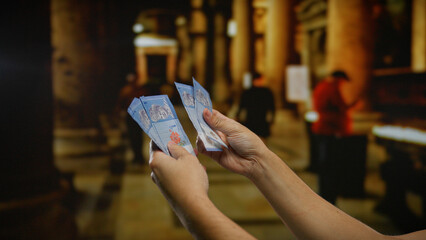 Man holding malaysian ringgit banknotes inside a church, highlighting a contrast between finance...