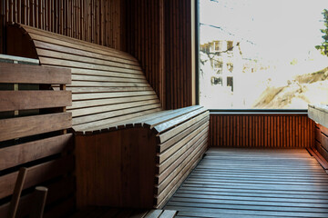 Modern wooden sauna interior with curved bench, natural light and minimalist design. Warm and...