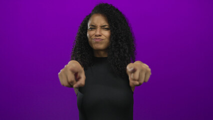 Woman pointing with a playful expression against a vibrant purple background