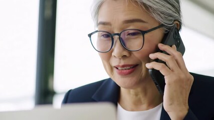 Focused businesswoman speaking on a phone in the office. - Powered by Adobe