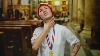 Woman wearing medal and headband appears contemplative in a church setting, showcasing a blend of sport and spirituality among ancient architecture.