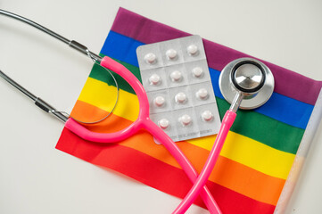 Rainbow flag, pills and stethoscope. 