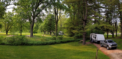 Panorama of a Travel trailer camping in the woods under the pines at Mississippi Palisades State Park, Illinois