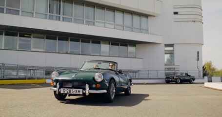 Stylish young couple rides a retro convertible on a sunny day