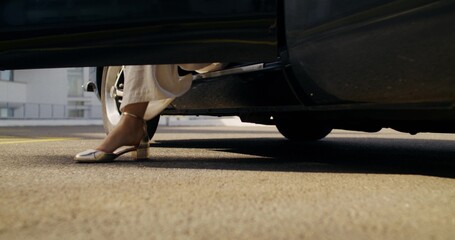 A woman gets out of a retro car. Close-up of her legs, unrecognizable person