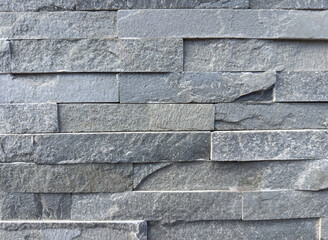 Textured stone wall background with gray slate bricks in horizontal pattern