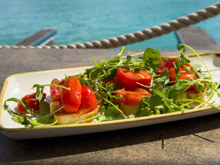 Fresh tomato and arugula bruschetta by the seaside
