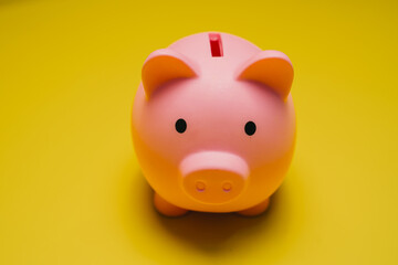 Saving money concept. Cute Pink Piggy Bank on Bright Yellow Background Representing Savings and...
