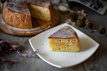 A piece of sweet pie on a white plate on a gray background for breakfast. A delicious pie for...