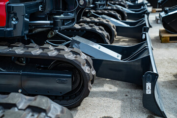 close up of industrial crawler tracks and metal dozer blades of compact construction machinery...