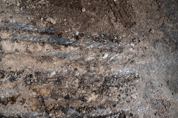 rough construction site ground surface with soil layers rocks and visible excavation machine marks showing earthwork texture and terrain prepared for building foundation and infrastructure work