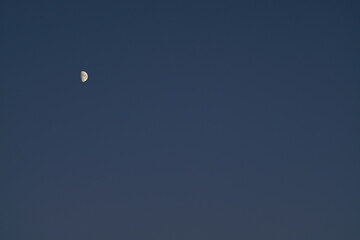 Abends am Himmel mit Mond in weiter Ferne