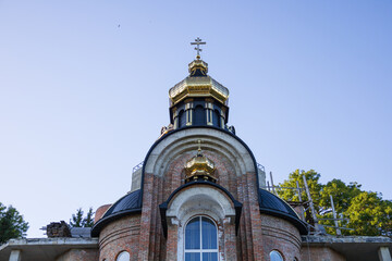 A church with a striking golden dome is under construction, adorned with intricate details,...