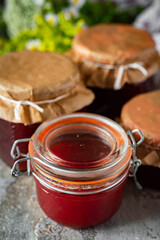 Thick plum jam for dessert in glass jars. Delicious plum jam. Vertical photo. Close-up