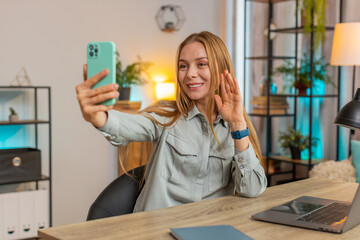 Caucasian middle-aged woman freelancer using smartphone shooting video call for social media posing...