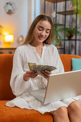 Planning budget. Rich happy young woman counting money cash using laptop calculate domestic bills...