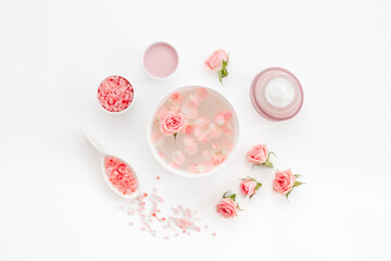 Spa organic cosmetic products with roses essential oil on white background top view