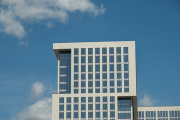 New white building apartment with modern design. Minimal architecture skyscraper against blue clear...