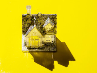 Fine vogue style house with glitter standing on a clean yellow surface. High value fashion home...